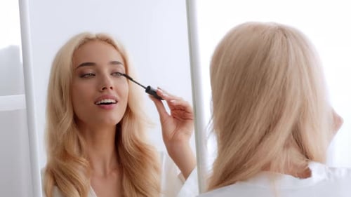 Morning Beauty Routine of a Young Woman Applying Mascara at Home