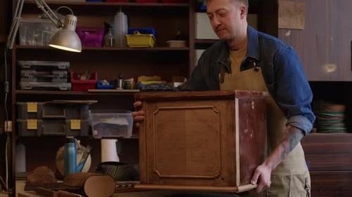 Man Restoring Old Furniture in Workshop