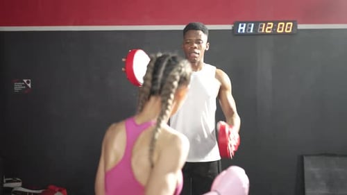 Man and woman practice boxing at the gym.