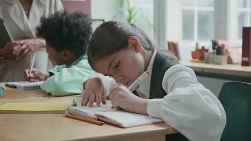 Fille absente dessinant dans un cahier lors d'un cours d'anglais