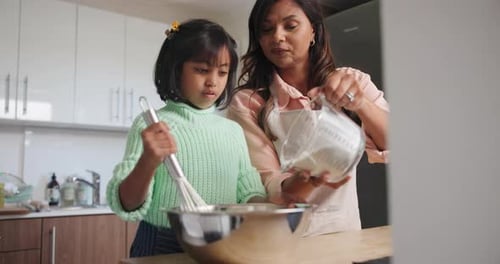 Child and Woman Baking Together in Kitchen