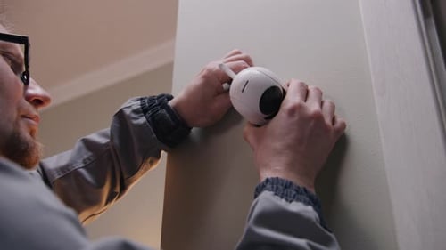 Man Installing Security Camera on Interior Wall