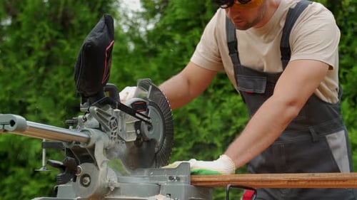 Professional Carpenter Works with a Circular Saw in the Backyard