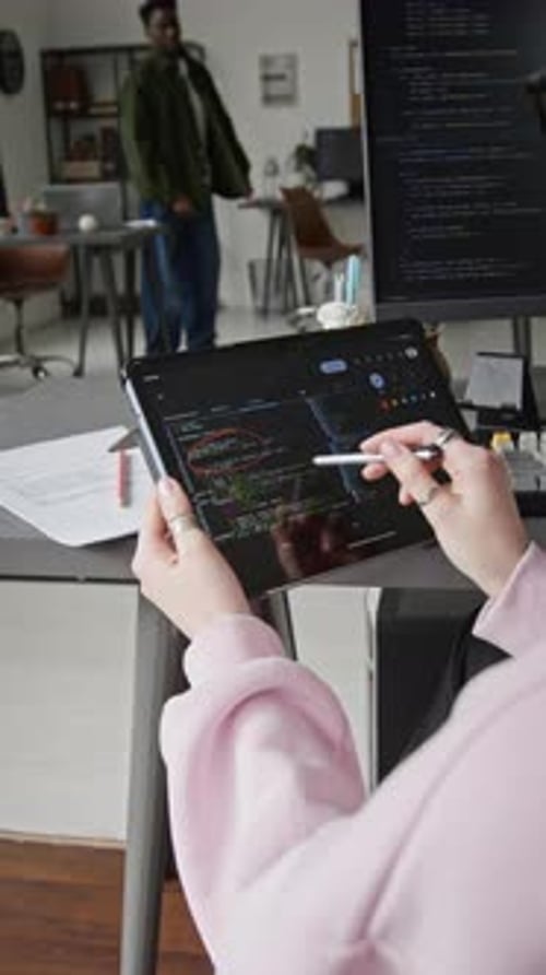 Female Developer Reviewing Script from Vibe Coding Agent on Tablet in Office