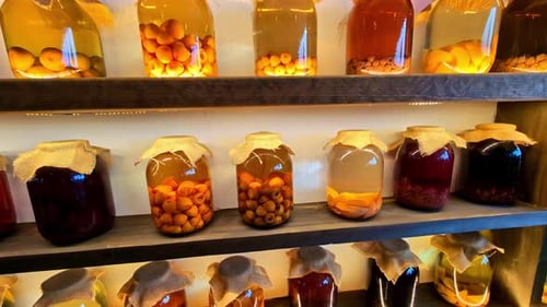 Les bocaux en verre contiennent des compotes faites maison à base de fruits, de pêches, d'abricots et de baies diverses.