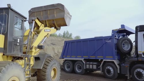 Wheel Loader Loading Dump Truck at Construction Site