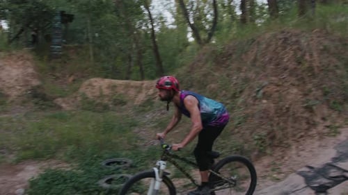 Courageous Man Riding Up Hill at Speed and Jumping Over Hole
