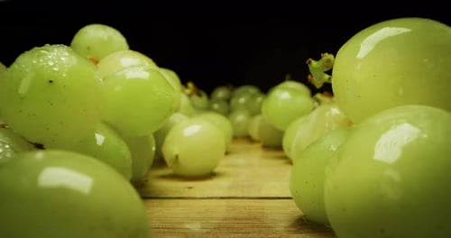 super macro slide shot of grapes on a wooden bench, in slow motion. Concept: food, fruit, nature