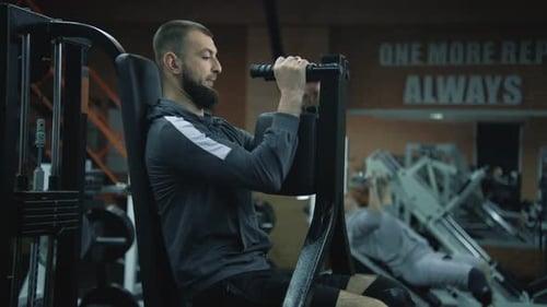 Athletic Man with with Prosthetic Leg Does Arms Exercises in Gym