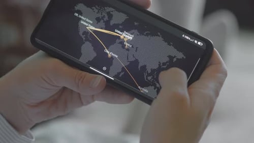 Hands Holding Phone Displaying World Cyber Attack Map