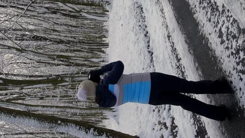 Vertical Video An Adult Woman with a Camera Takes Pictures of a Winter Forest