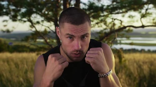 Muscular Man in Sportswear Boxing to the Camera Standing on the Field