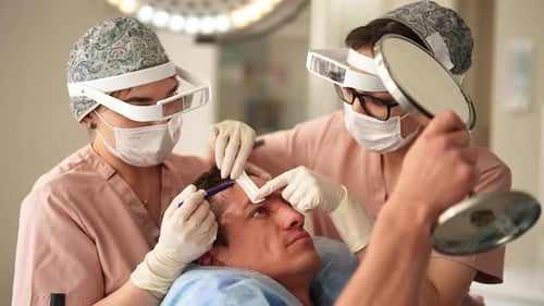Surgeons Preparing Patient for Hair Transplant Procedure