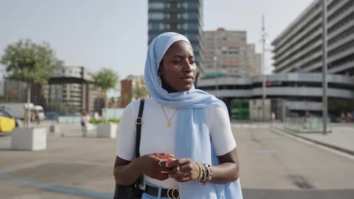 Femme musulmane africaine moderne marchant dans la ville