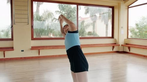 Woman stretching in bright dance studio