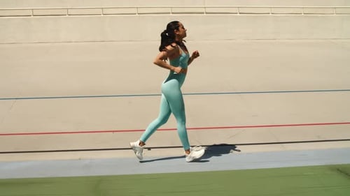 Woman Runner Running on Racetrack. Fit Woman Training Run Workout on Stadium