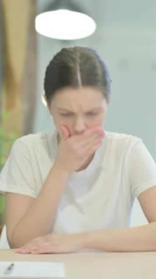 Coughing Sick Young Woman Sitting in Office, vertical video
