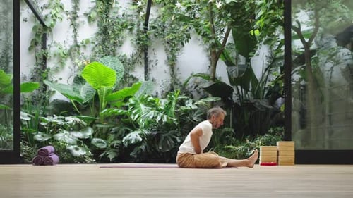 Man practicing relaxation posture in green garden with grounded focus
