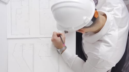 Architect Working on Blueprints in Bright Office