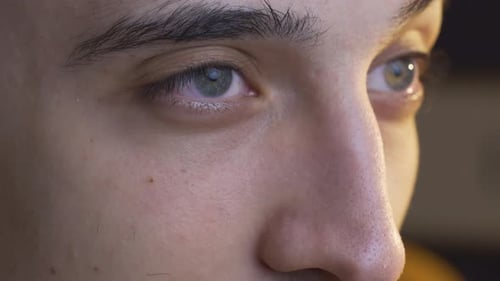 Close-up eyes of thoughtful young man.