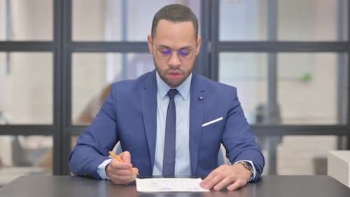 Mixed Race Businessman Working on Documents in Office
