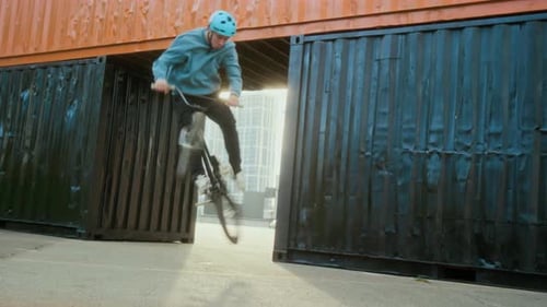 Young Adult Does BMX Tricks on a Bike