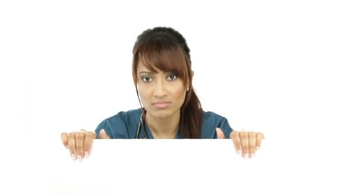 Woman in Scrubs With a Blank Sign Thinks