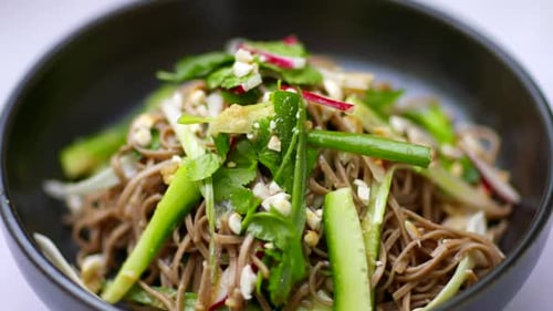 Noodle salad bowl asian food spinning in close up. Wholefoods and vegetarian dishes. Healthy plant b