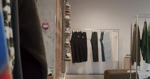 Retail Store Interior Clothing and Shoes Displayed on Hangers and Shelves