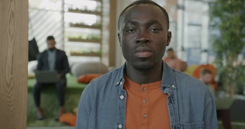 Slow Motion Portrait of Serious African American Businessman Standing in Coworking Place with People