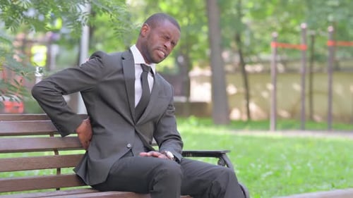 Man in Suit on Bench Experiences Back Pain