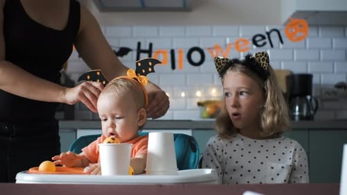 Mother Dresses Children in Halloween Costumes at Home