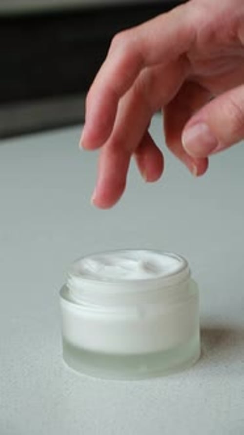 Finger Touches White Cream in Jar, Skin Care