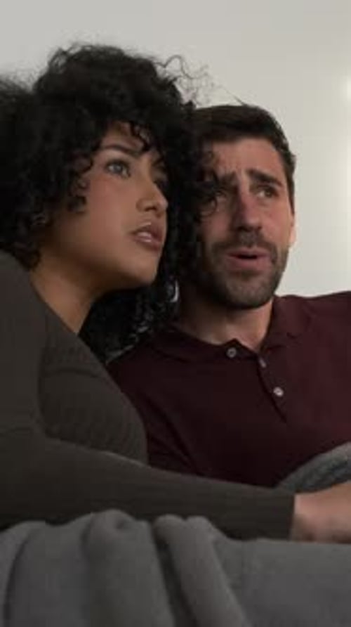 Couple Watching Frightening Movie at Home on Couch