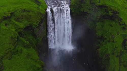 La cascada de Skogafoss que fluye a través de verdes acantilados en Islandia