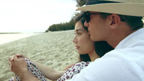 Beautiful, Relaxed Young Couple, Cuddling on the Beach, Laying in the Sand,