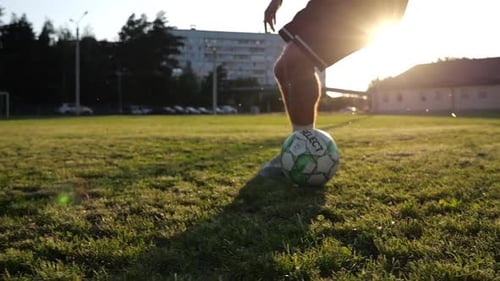 Male Feet of Professional Footballer Shows Tricks with Ball While Running at Green Field Legs of
