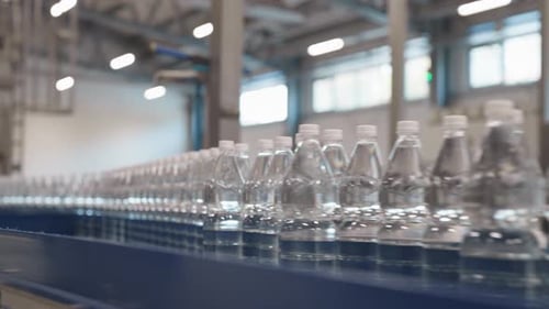 Unlabeled Bottled Water On The Production Line Moving Along A Conveyor System In The Factory. -