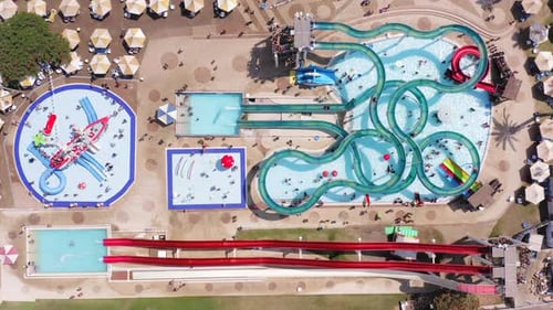 Top down aerial footage of a large and crowded Water park.