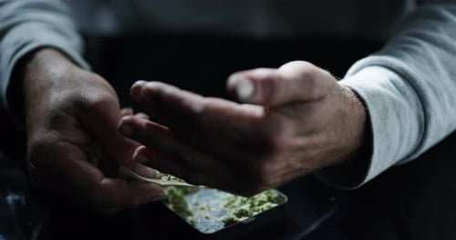 Hands, cannabis and paper on table for joint, ready or 420 for wellness, benefits or addiction