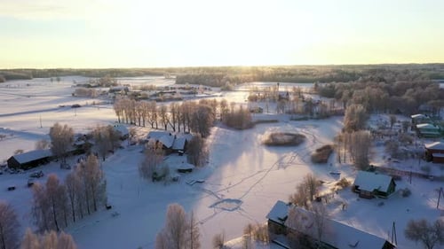 Small rural town in cold snowy winter on sunny day, aerial drone shot