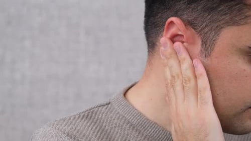 Man Holding Ear Close Up Studio Shot