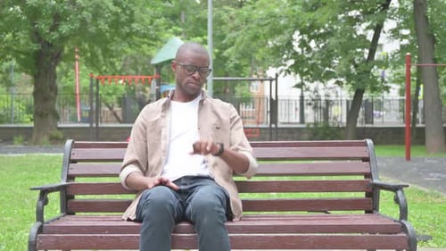 Man Sitting on Park Bench Waiting