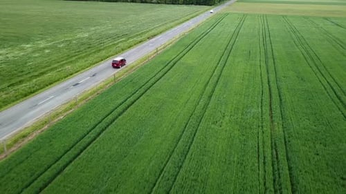 Aerial landcape shot following a claret van driving on road agricultural area windy weather zala cou