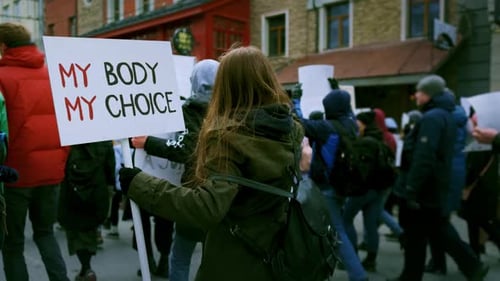 Protestors Marching with Signs in Urban Setting