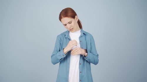 Woman Rubbing Aching Wrist in Studio