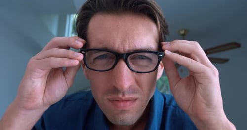 Portrait of a Young Male Put on Glasses to See Better Indoors