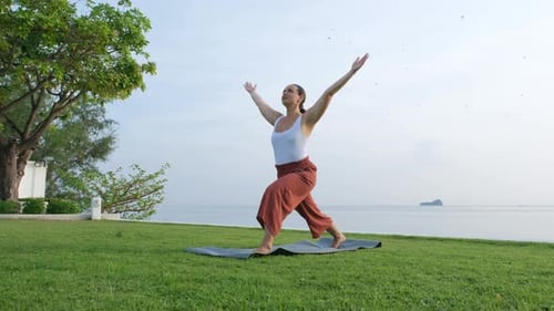 Morgen-Yoga-Asana über der Meeresküste von einer jungen Frau