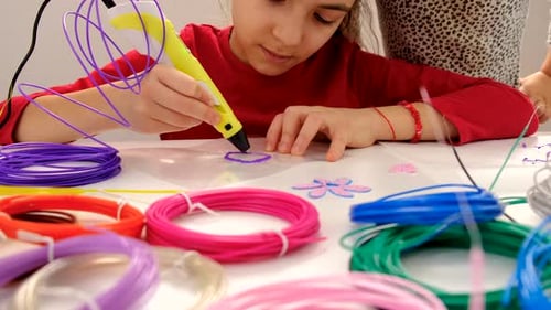 Child Using a 3D Printing Pen at Table