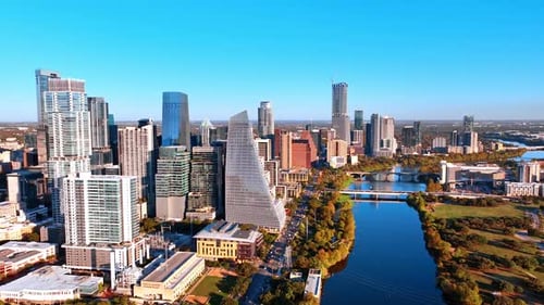 Multiple cars ride along the Colorado River crossing the scenery of Austin, Texas, USA.